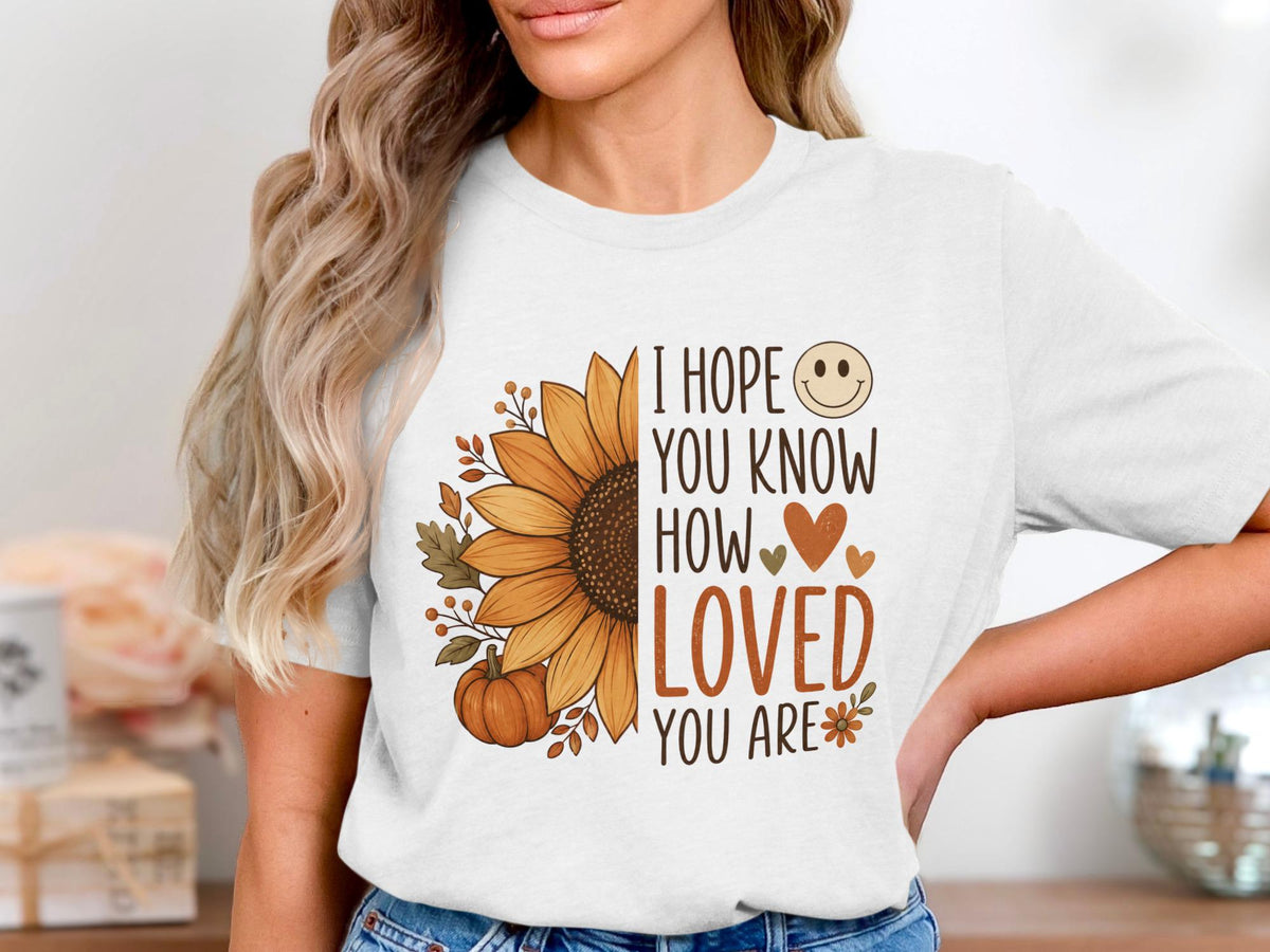 White t-shirt with sunflower, pumpkin, and text "I hope you know how loved you are".