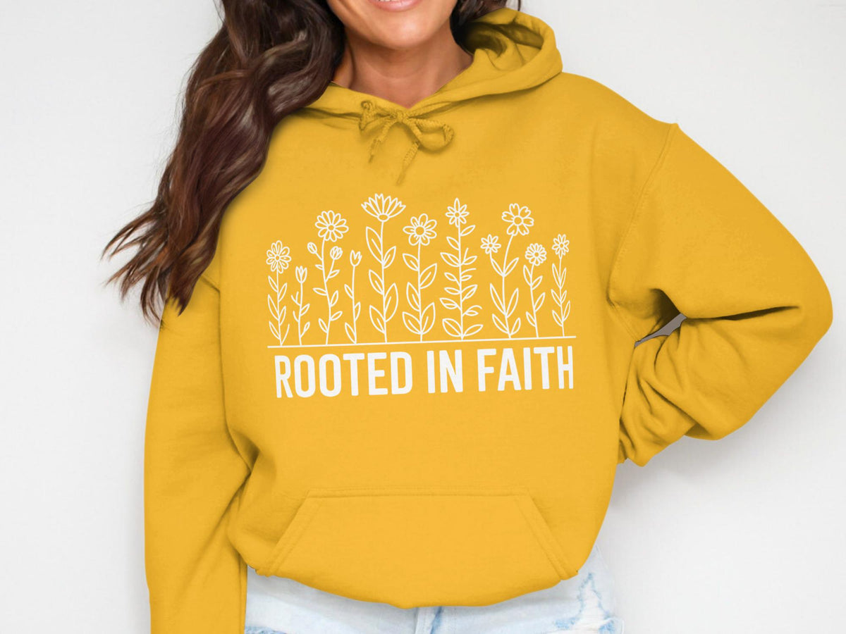 Yellow hoodie with white floral design and text "ROOTED IN FAITH".
