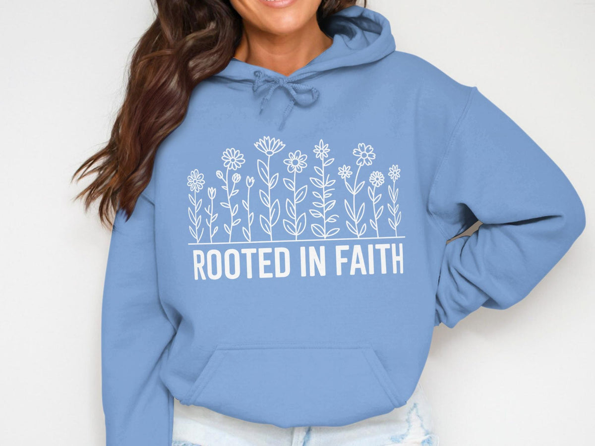 Light blue hoodie with "ROOTED IN FAITH" text and white floral line art.