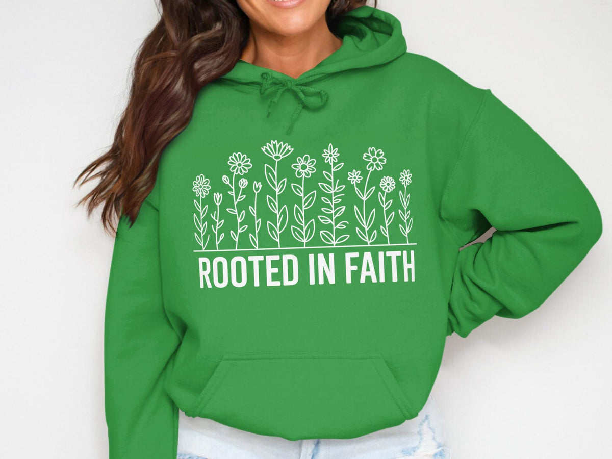 Green hoodie with white flowers and text "ROOTED IN FAITH".