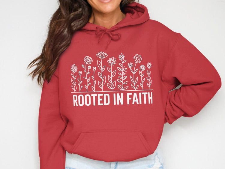 Red hoodie with white floral line art and the text "ROOTED IN FAITH".