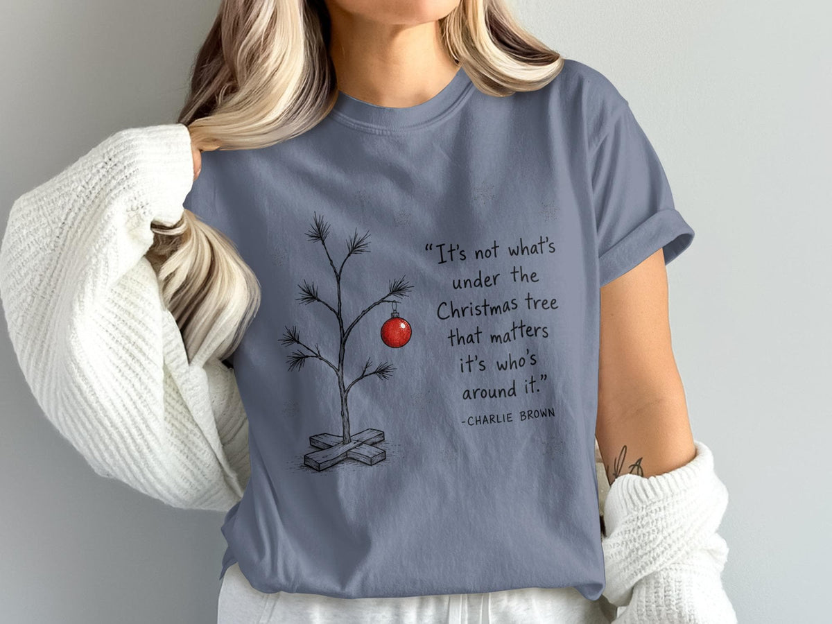 Charlie Brown quote about Christmas tree on a blue t-shirt.