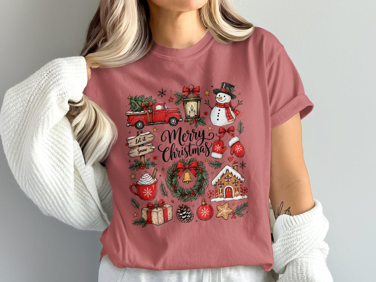 Merry Christmas graphic with truck, snowman, gingerbread house, and hot cocoa on pink shirt.