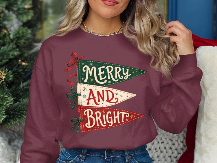 Maroon sweatshirt with "Merry And Bright" text on stacked pennants.