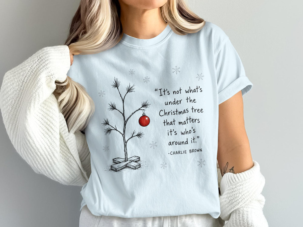 Light blue t-shirt with a minimalist Charlie Brown quote and Christmas tree graphic.
