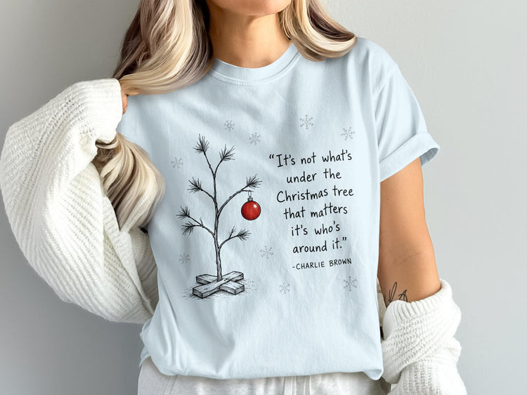 Light blue t-shirt with a minimalist Charlie Brown quote and Christmas tree graphic.