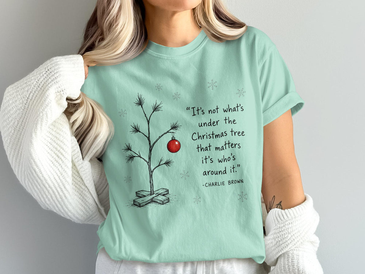 Mint green t-shirt with Charlie Brown Christmas quote and drawing of a minimalist tree.