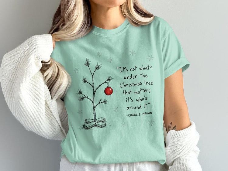 Mint green t-shirt with Charlie Brown Christmas quote and drawing of a minimalist tree.