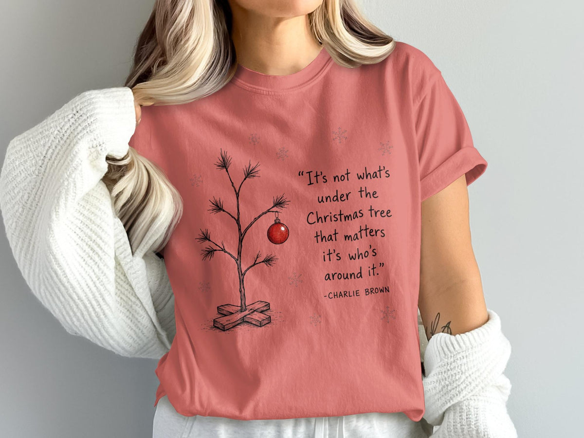 Peach t-shirt with Charlie Brown Christmas tree quote and snowflakes.