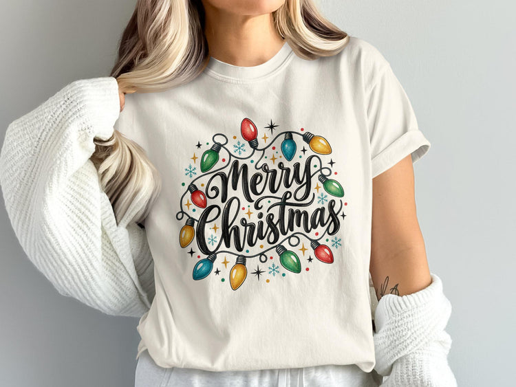 Cream t-shirt with "Merry Christmas" text surrounded by colorful festive lights.
