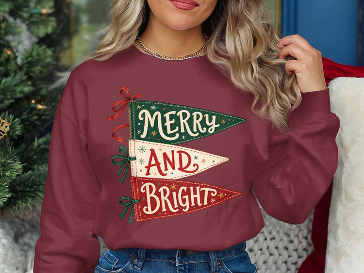 Maroon sweatshirt with stacked pennants reading "Merry," "And," and "Bright" in festive font.
